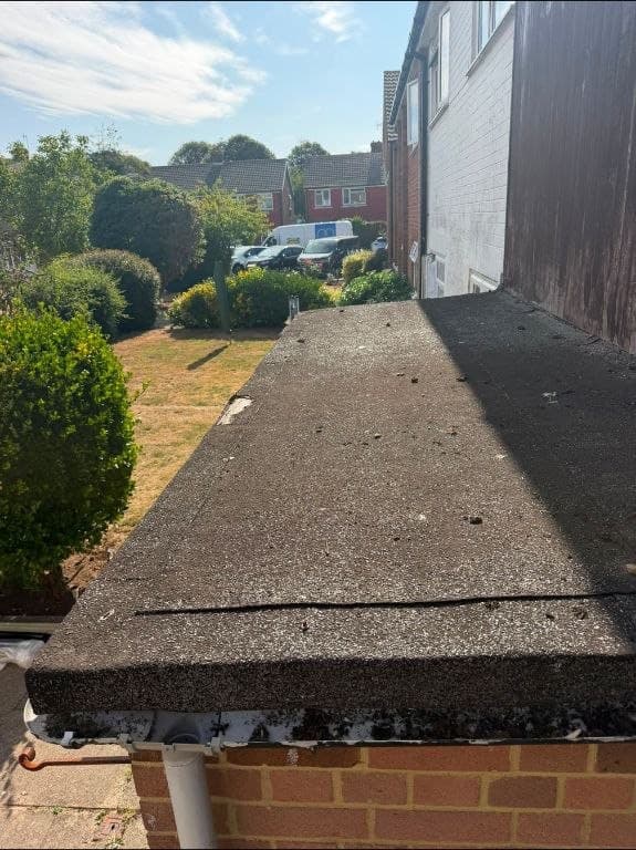 Old black felt flat roof before GRP fibreglass replacement - West Sussex