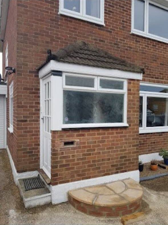 Old porch with dated white door before refurbishment